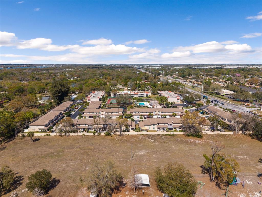 An aerial view shows a multi-building apartment complex surrounded by trees and open land — 9530 STARKEY ROAD, SEMINOLE, FL