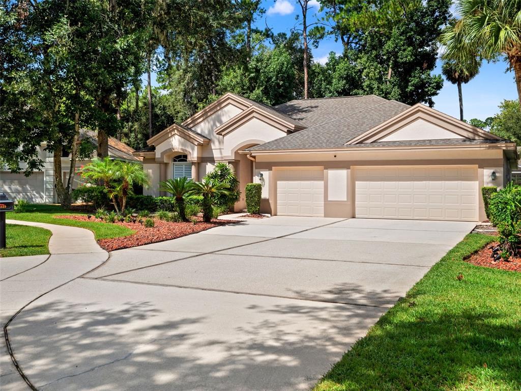A single-story suburban house with a beige exterior, a three-car garage, and a concrete driveway — 5325 LAKE BLUFF TERRACE, SANFORD, FL