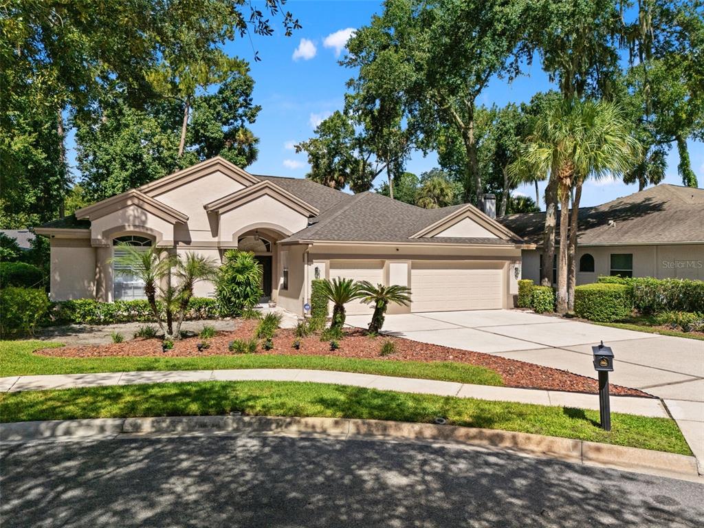 A single-story house with a beige stucco exterior, a two-car garage, and a landscaped yard — 5325 LAKE BLUFF TERRACE, SANFORD, FL