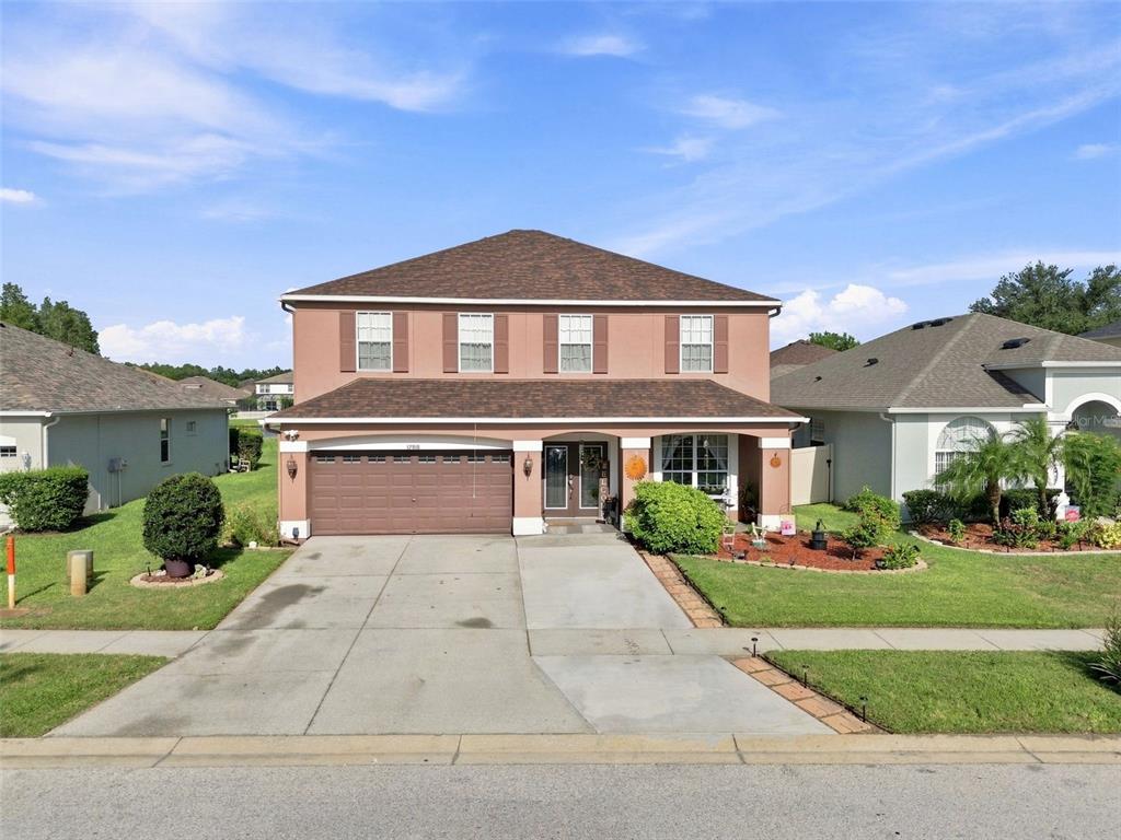 A two-story suburban house with a brown roof, tan stucco exterior, and a two-car garage — 17919 AYRSHIRE BOULEVARD, LAND O LAKES, FL