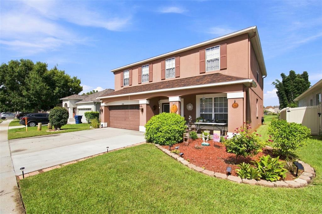 A two-story house with a brown stucco exterior, a two-car garage, and a front garden — 17919 AYRSHIRE BOULEVARD, LAND O LAKES, FL