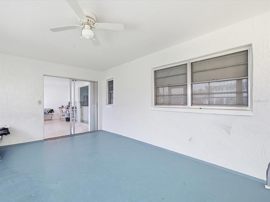 A covered patio with a blue floor, white walls, a ceiling fan, and sliding glass doors — 4069 GULFVIEW DRIVE, HERNANDO BEACH, FL