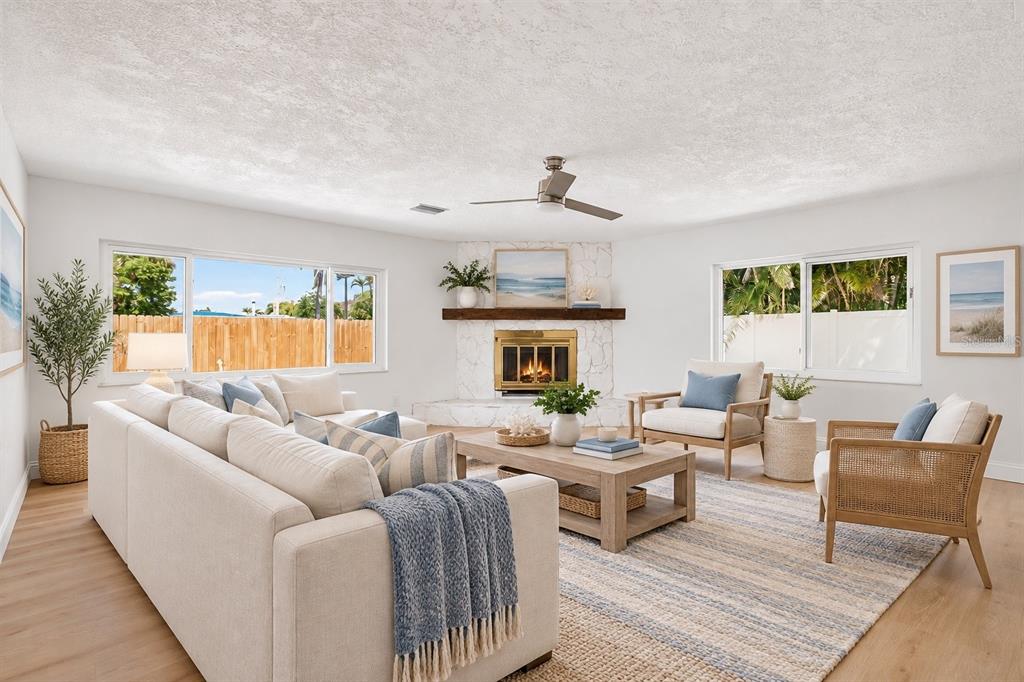 An empty living room with white walls, light wood-look flooring, and a large front window — 7919 CAUSEWAY BOULEVARD S, ST PETERSBURG, FL