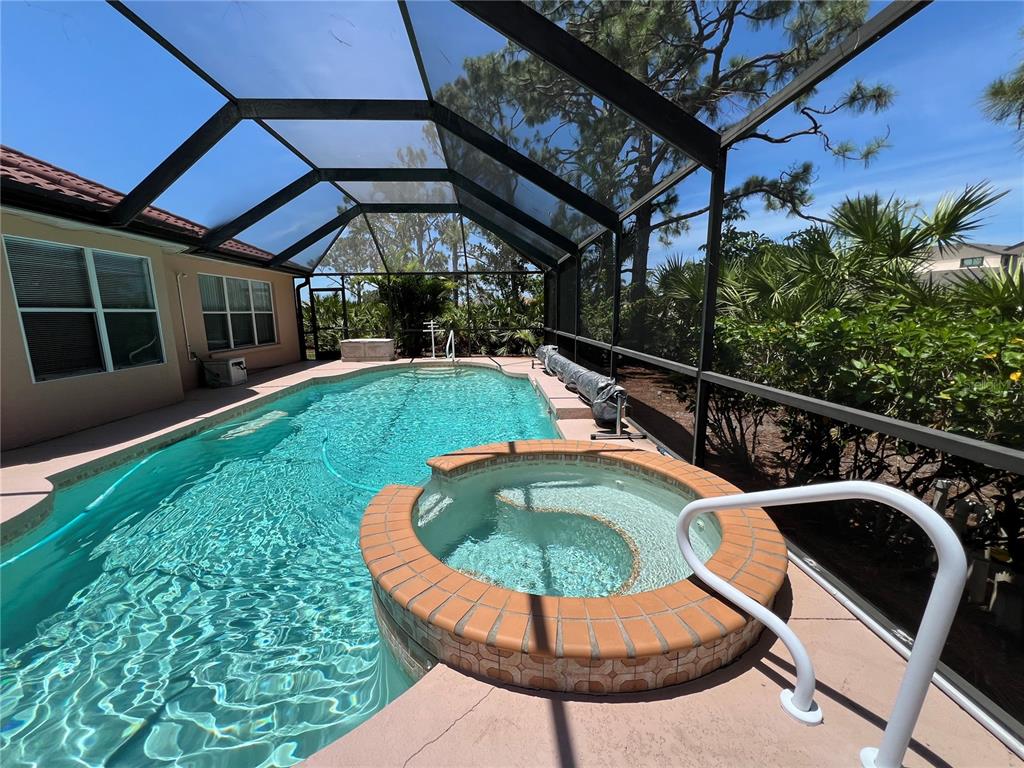 A screened-in swimming pool and raised circular spa with brick-style coping on a patio — 4005 BIG PASS LANE, PUNTA GORDA, FL