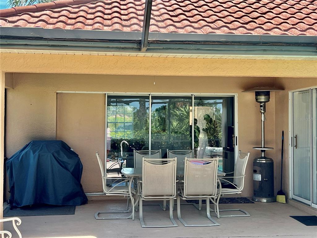 A covered patio features a dining set, a covered grill, and a standing outdoor heater — 4005 BIG PASS LANE, PUNTA GORDA, FL