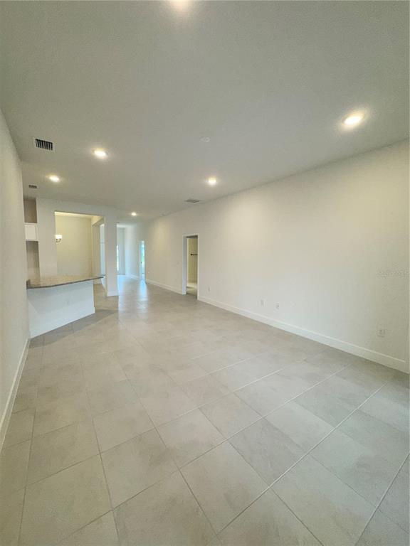 An open-concept living area features light-colored tile flooring, recessed lighting, and a kitchen breakfast bar — 2675 AVERLAND LOOP, NORTH PORT, FL