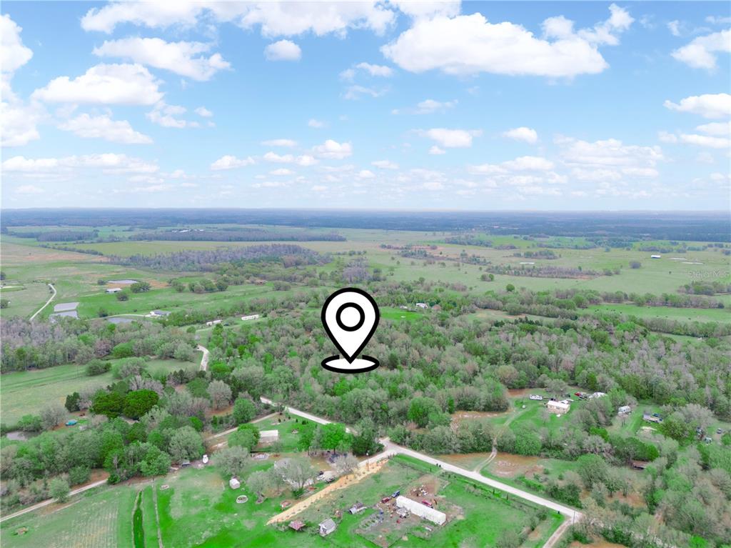 An aerial view shows a rural landscape with scattered houses, trees, and a location pin — ANGUS ROAD, POLK CITY, FL