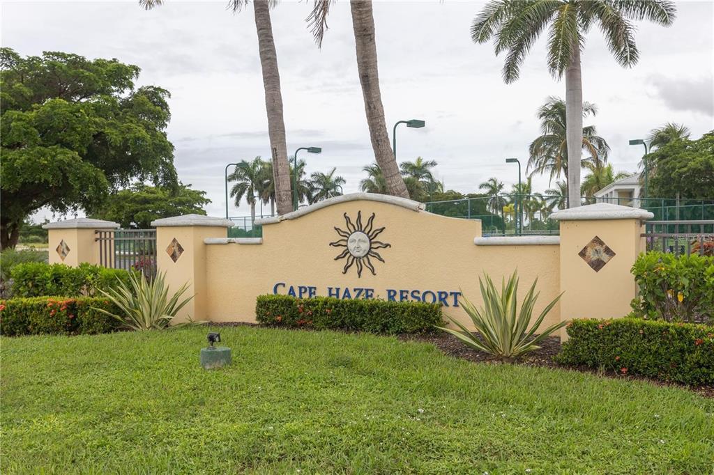 A beige stucco entrance sign for Cape Haze Resort features a sun emblem and landscaping — 8403 PLACIDA ROAD UNIT 303, PLACIDA, FL