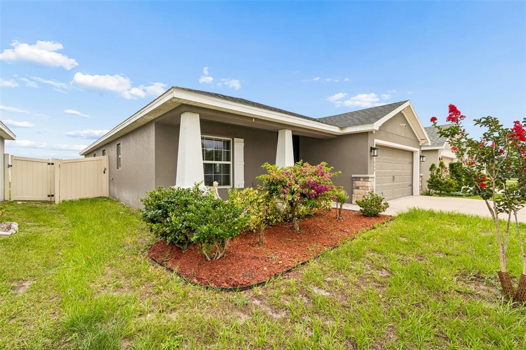 A single-story house with a gray stucco exterior, a front porch, and a two-car garage — 11669 STONE PINE STREET, RIVERVIEW, FL