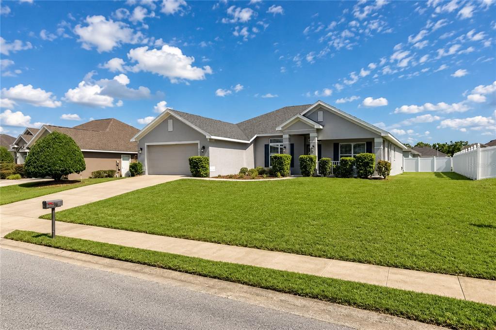 A single-story suburban house with a gray exterior, two-car garage, and a manicured front lawn — 4321 NW 1ST COURT ROAD, OCALA, FL