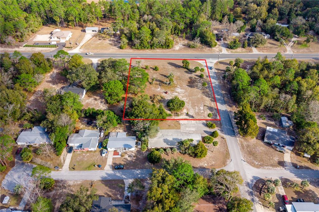 An aerial view shows a vacant, rectangular lot outlined in red next to a paved road — TBD NE STATE RD 121, LOT 2, WILLISTON, FL