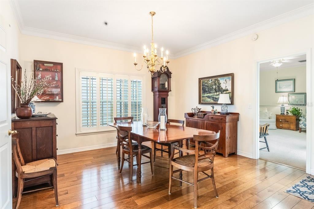 A dining room features a wooden table, chairs, a grandfather clock, and hardwood flooring — 2175 S COUNTRYSIDE CIRCLE, ORLANDO, FL