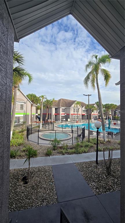 A view from a covered patio overlooking a swimming pool and apartment buildings — 3100 PARKWAY BOULEVARD UNIT 123, KISSIMMEE, FL