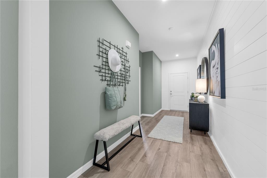 A hallway features light green walls, white shiplap, a bench, and a console table — 2230 LINK LOOP, ST CLOUD, FL