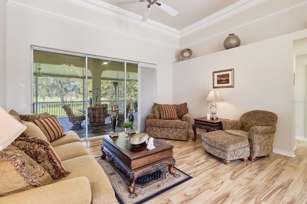 A living room features wood flooring, a coffered ceiling, and sliding glass doors to a patio — 564 N AFTERGLOW CIRCLE, CRYSTAL RIVER, FL