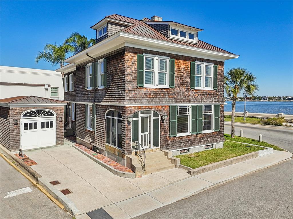 A two-story shingle-sided house with a detached garage sits on a corner lot near water — 178 AVENIDA MENENDEZ, ST AUGUSTINE, FL