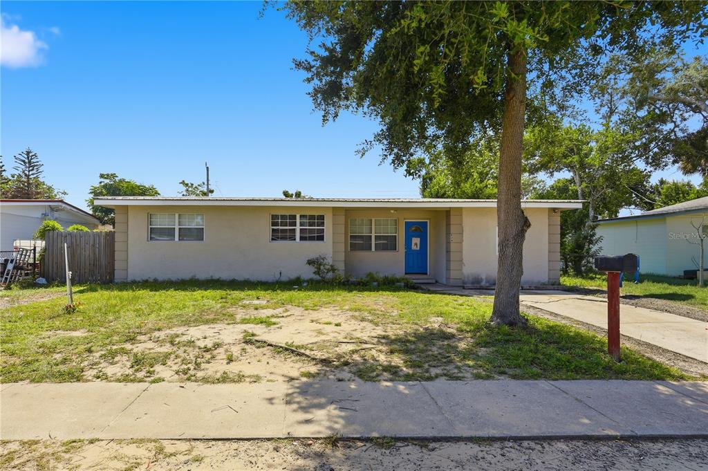 A single-story house with a blue front door, a concrete driveway, and a large tree — 934 LEWIS DRIVE, DAYTONA BEACH, FL