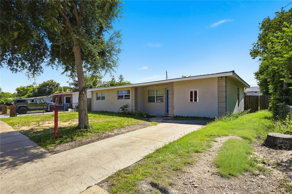 A single-story house with a concrete driveway, a large tree, and a red mailbox — 934 LEWIS DRIVE, DAYTONA BEACH, FL