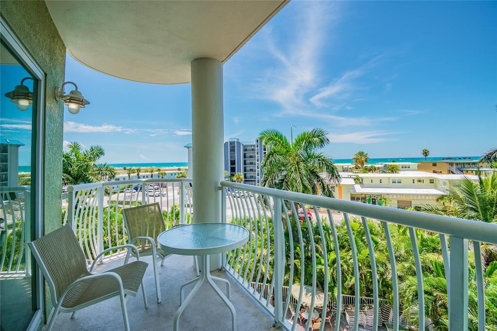 An aerial view of a multi-story green apartment building with a swimming pool and landscaping — 11605 GULF BOULEVARD UNIT 402, TREASURE ISLAND, FL