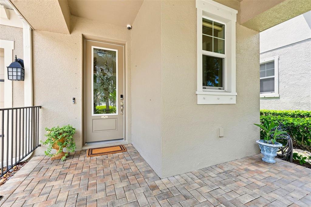A beige front door with a glass insert sits on a paved porch — 14507 ROCKY BROOK DRIVE, TAMPA, FL