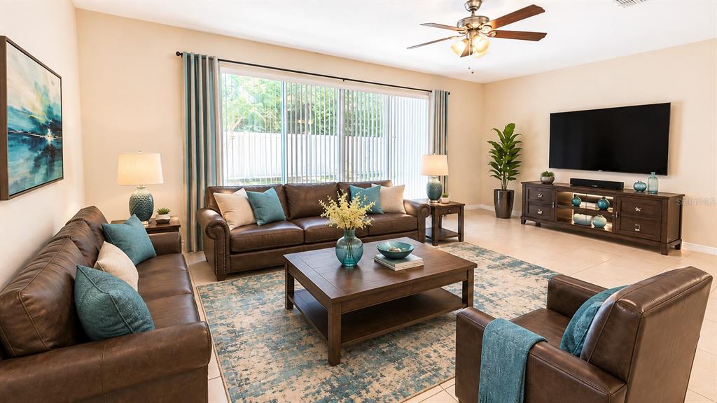 A living room features brown leather furniture, a wooden coffee table, and a large television — 103 MAYO COURT, OVIEDO, FL