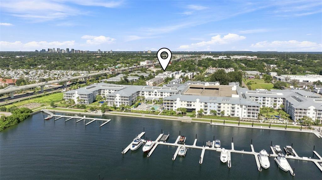 An aerial view shows a multi-story apartment complex situated along a marina with docked boats — 4810 W MCELROY AVENUE UNIT 3, TAMPA, FL