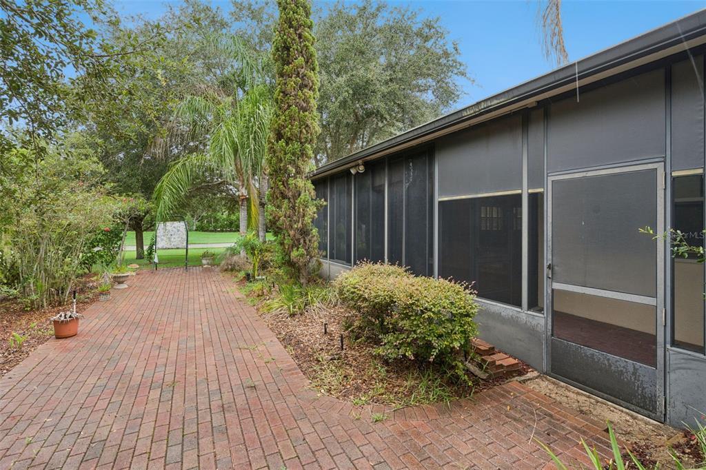 A single-story house with a two-car garage and a large tree in the front yard — 100 FLAME VINE WAY, GROVELAND, FL
