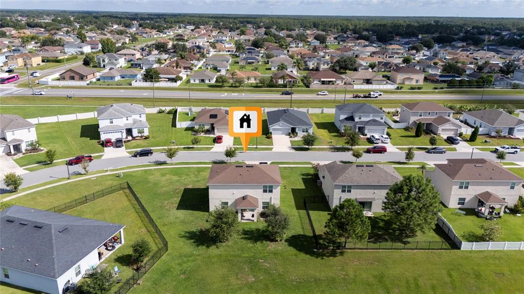 An aerial view shows a suburban neighborhood with houses, lawns, and a nearby road — 370 QUARRY ROCK CIRCLE, KISSIMMEE, FL