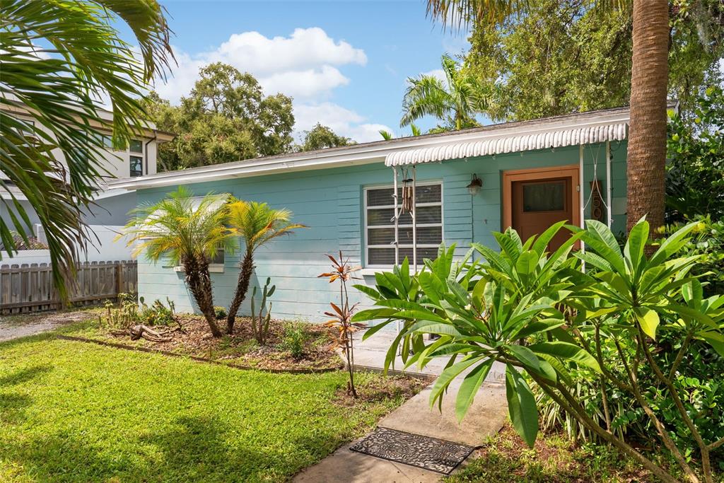 A light blue, single-story house with a white awning and a front yard with plants — 4501 26TH AVENUE S, ST PETERSBURG, FL