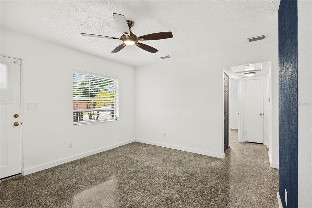 An empty room with white walls, a ceiling fan, a window, and gray carpeted flooring — 4501 26TH AVENUE S, ST PETERSBURG, FL