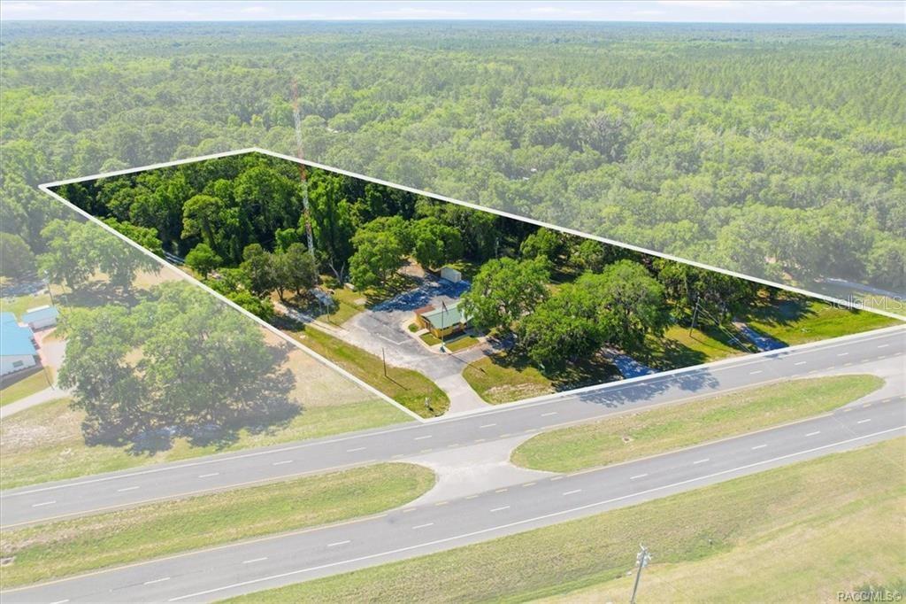 An aerial view shows a small building and a tall radio tower on a lot — 18150 SE HIGHWAY 19, INGLIS, FL