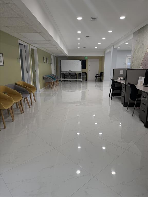 A bright office waiting area features white tile flooring, yellow and gray chairs, and cubicles — 1404-1412 W COLONIAL DRIVE, ORLANDO, FL