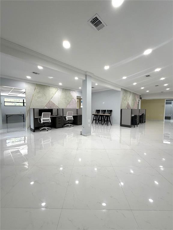 A modern office space features white marble-look tile flooring, cubicle workstations, and recessed ceiling lighting — 1404-1412 W COLONIAL DRIVE, ORLANDO, FL