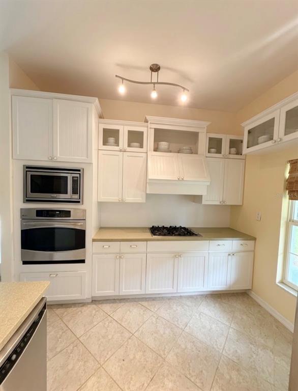 A kitchen features white cabinetry, stainless steel appliances, a gas cooktop, and light-colored tile flooring — 3030 SE HIGHWAY 31, ARCADIA, FL