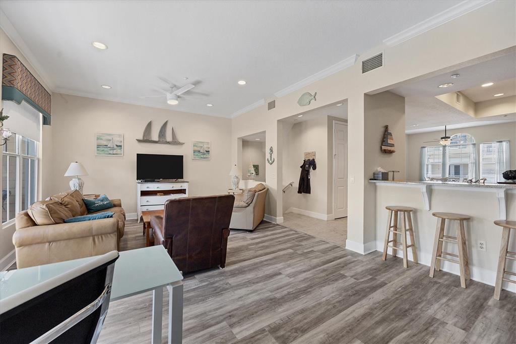 A living room with wood-look flooring, a leather recliner, a sofa, and a kitchen bar — 10380 LONGSHORE ROAD UNIT 77, PLACIDA, FL
