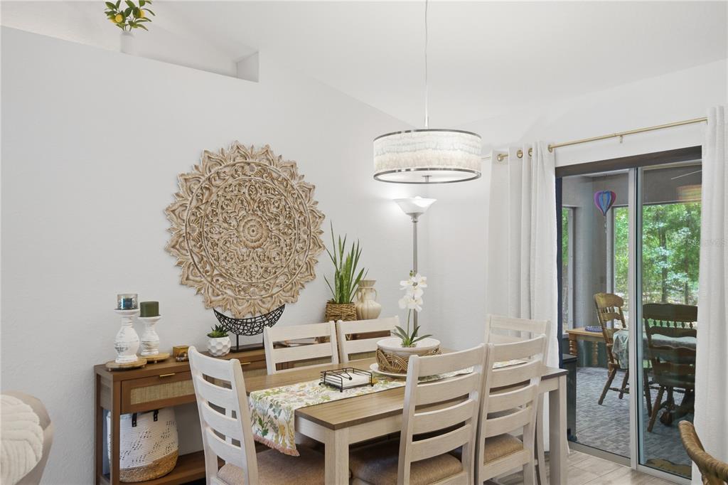 A dining room features a wooden table, white chairs, a decorative wall medallion, and sliding doors — 21635 SW 82ND LOOP, DUNNELLON, FL