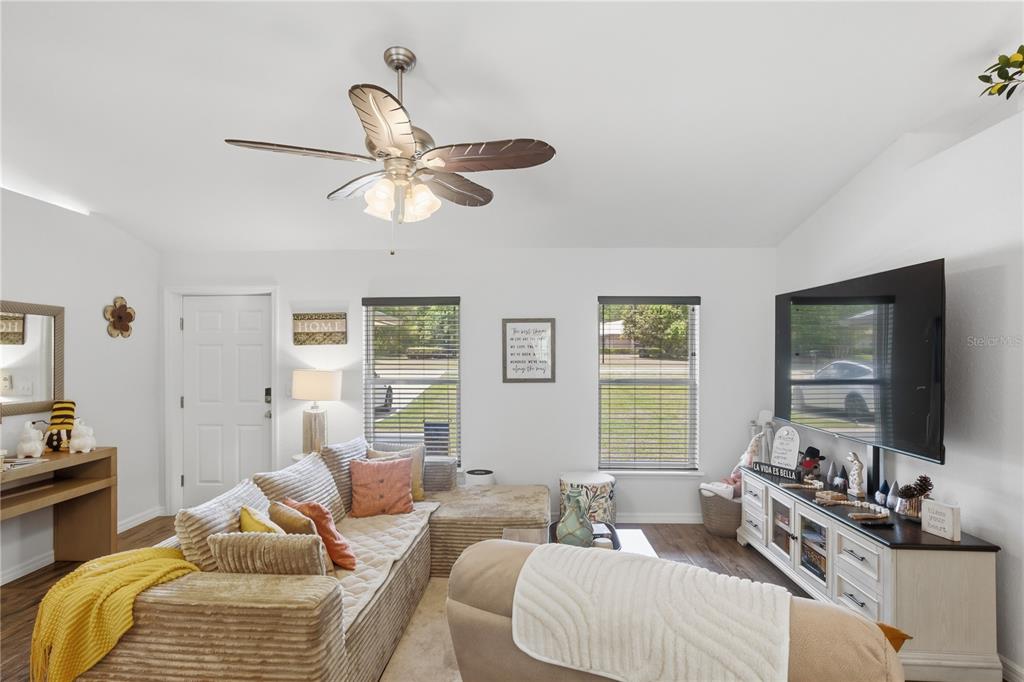 A living room features a sectional sofa, a ceiling fan, and a television on a console — 21635 SW 82ND LOOP, DUNNELLON, FL