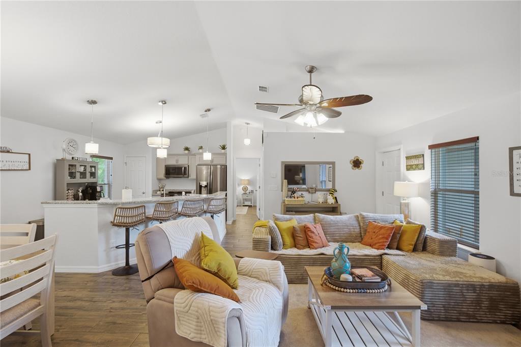 An open-concept living room and kitchen area with a sectional sofa and breakfast bar — 21635 SW 82ND LOOP, DUNNELLON, FL