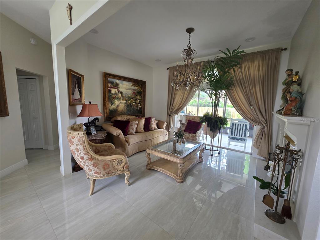 A living room features tile floors, a chandelier, a sofa, and a large window — 802 KAYWOOD DRIVE, ORLANDO, FL
