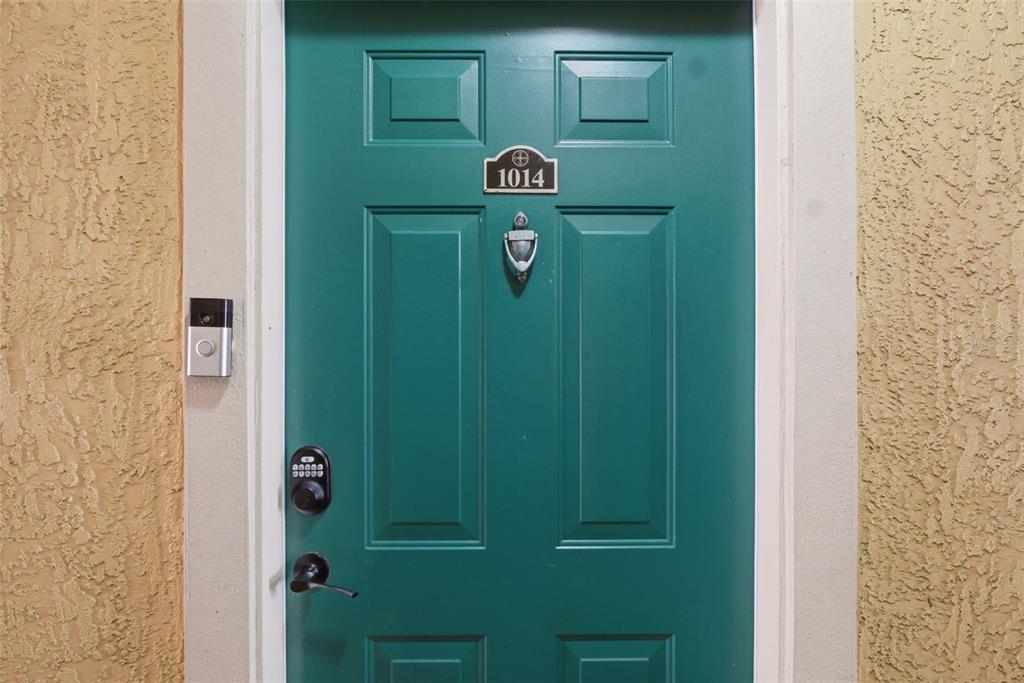 A teal front door with a digital keypad, door knocker, and doorbell camera — 2739 VIA CAPRI UNIT 1014, CLEARWATER, FL