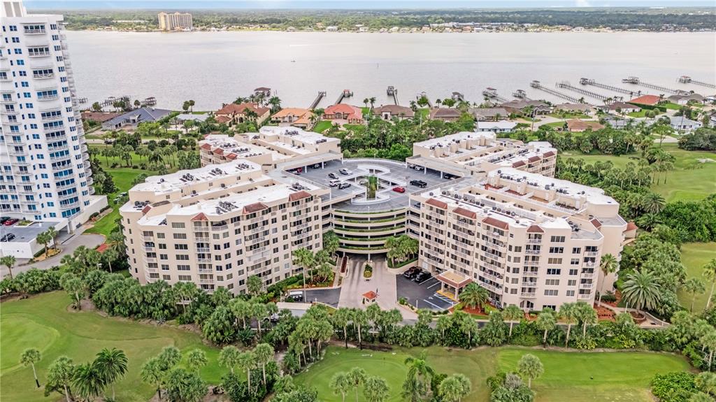 An aerial view of a large multi-story apartment complex surrounded by a golf course — 3 OCEANS WEST BOULEVARD UNIT 2B2, DAYTONA BEACH SHORES, FL
