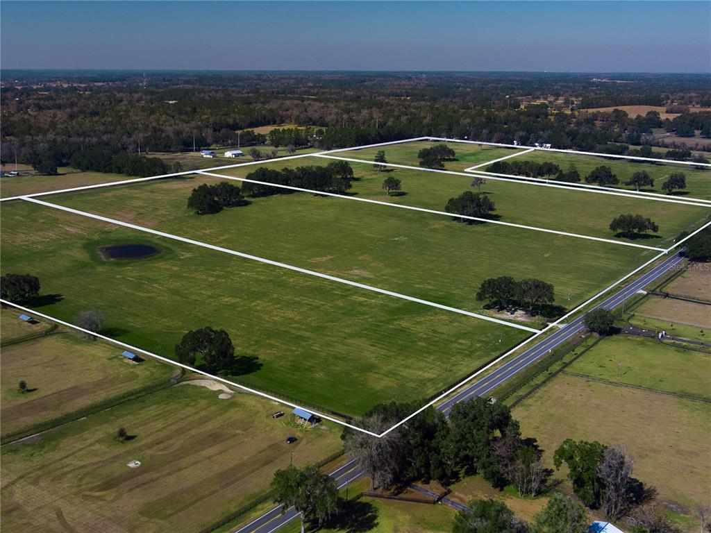 An aerial view shows a large, fenced grassy field divided into multiple rectangular plots — TBD NW GAINESVILLE ROAD, REDDICK, FL