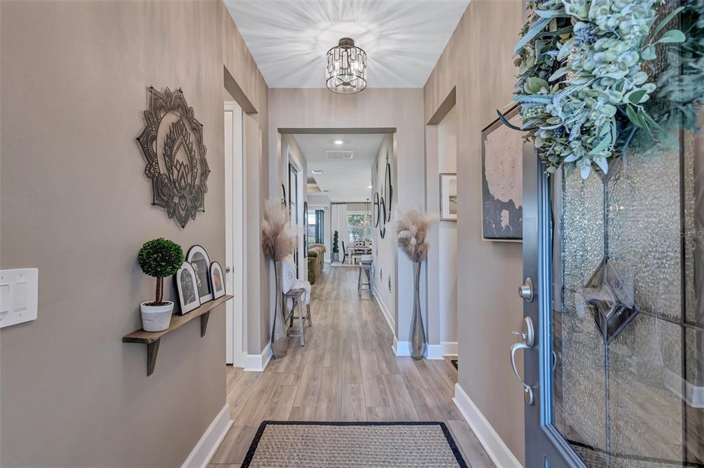 A view from a front entryway looking down a hallway toward an open living area — 711 PINTAIL COVE, BRADENTON, FL