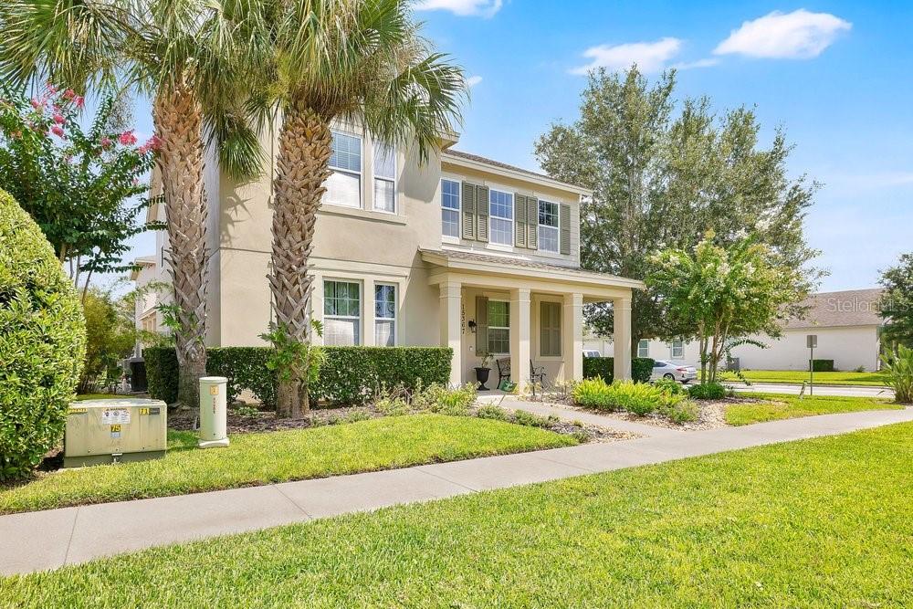 A two-story suburban house with a covered front porch, palm tree, and landscaped yard — 15367 SHONAN GOLD DRIVE, WINTER GARDEN, FL