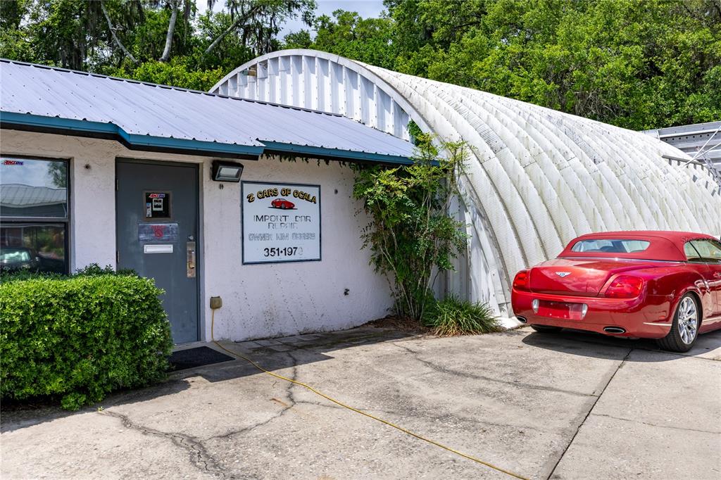 A red convertible is parked next to a white building with a metal roof — 3700 N US HIGHWAY 441, OCALA, FL