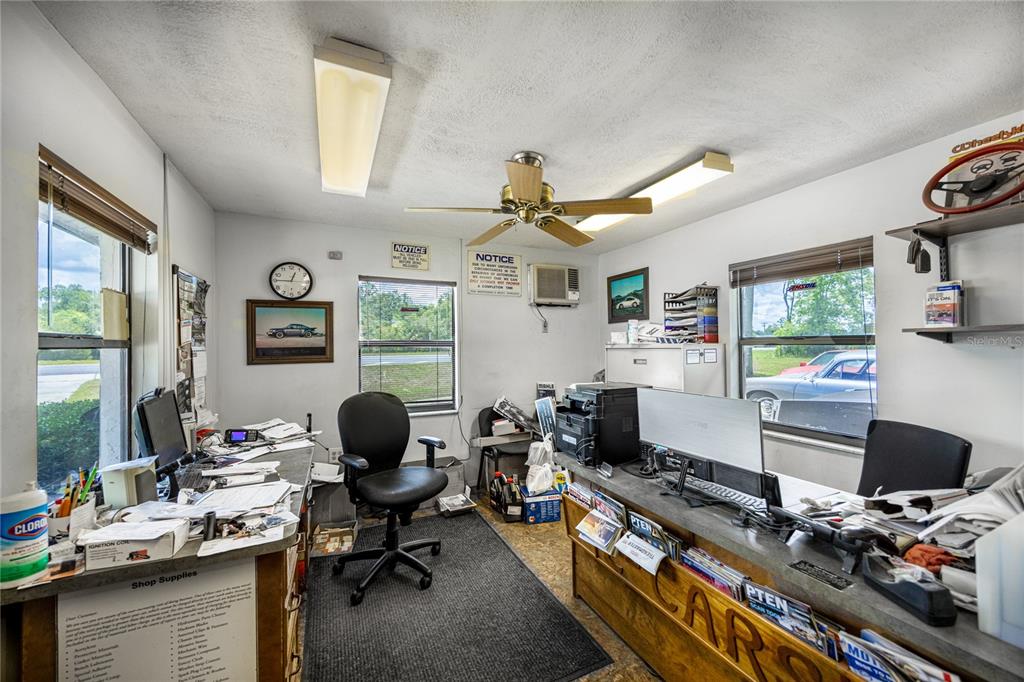 An office space features two desks, a rolling chair, windows, and fluorescent ceiling lighting — 3700 N US HIGHWAY 441, OCALA, FL