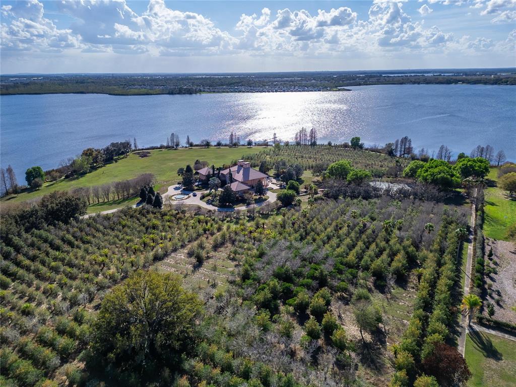 An aerial view of a large tan mansion with a circular driveway and a fountain — 501 ADAMS BARN ROAD, AUBURNDALE, FL