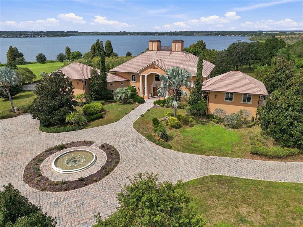 An aerial view of a large, multi-story peach-colored mansion with a pool and patio — 501 ADAMS BARN ROAD, AUBURNDALE, FL