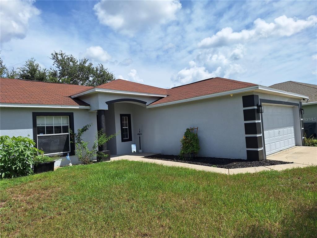 A single-story house with a gray exterior, a red roof, and an attached garage — 327 PUFFER COURT, POINCIANA, FL