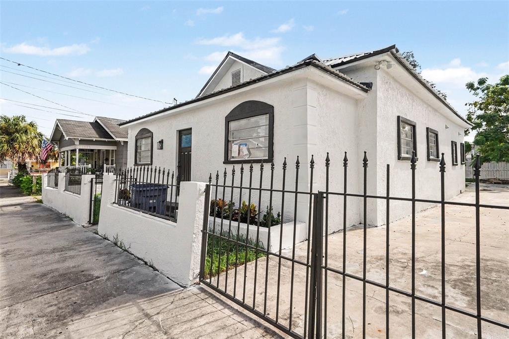 A white stucco house with a black metal fence and a concrete driveway — 2923 SANCHEZ STREET, TAMPA, FL